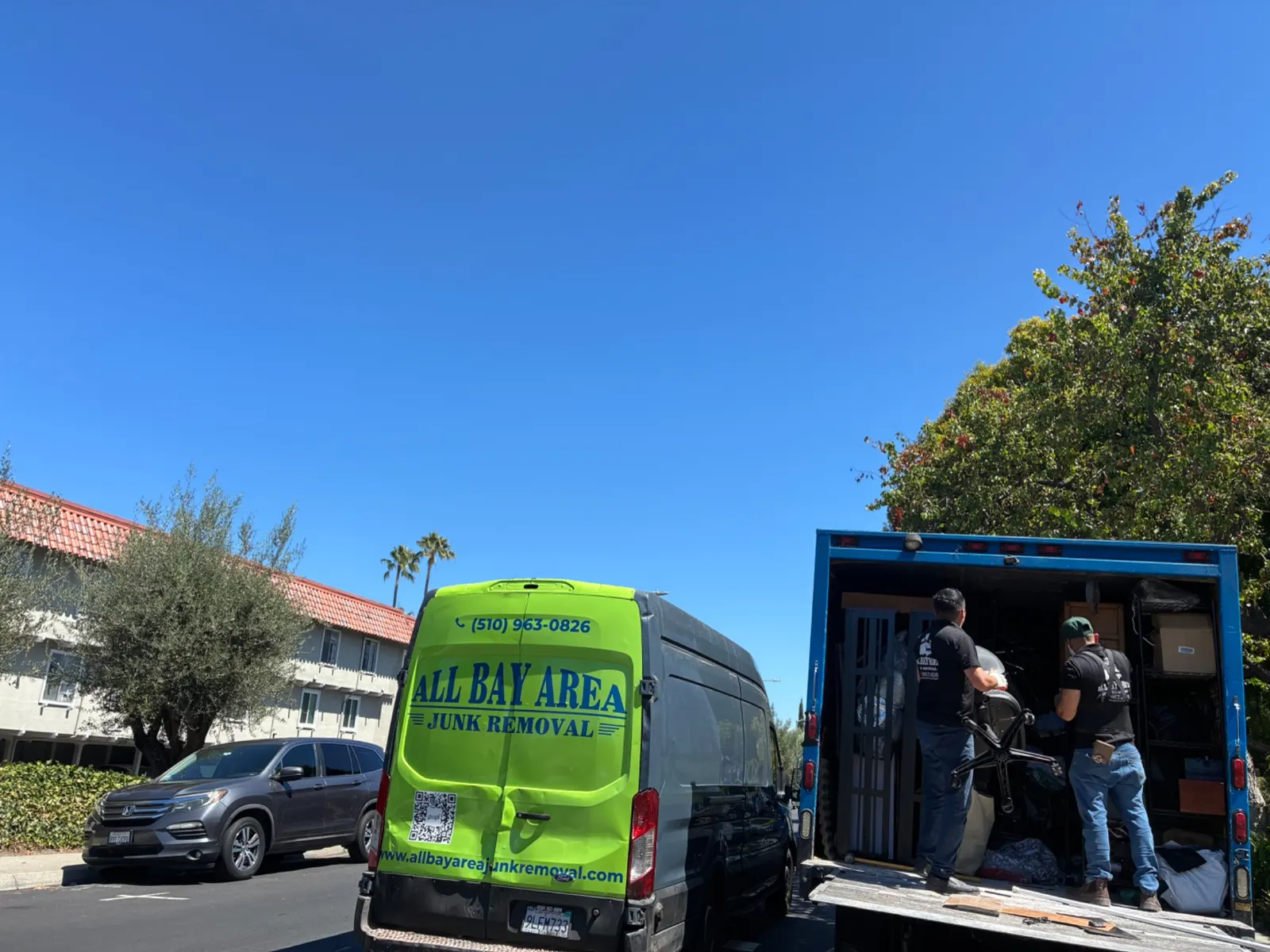 Crew loading the green All Bay Area Junk Removal van and truck