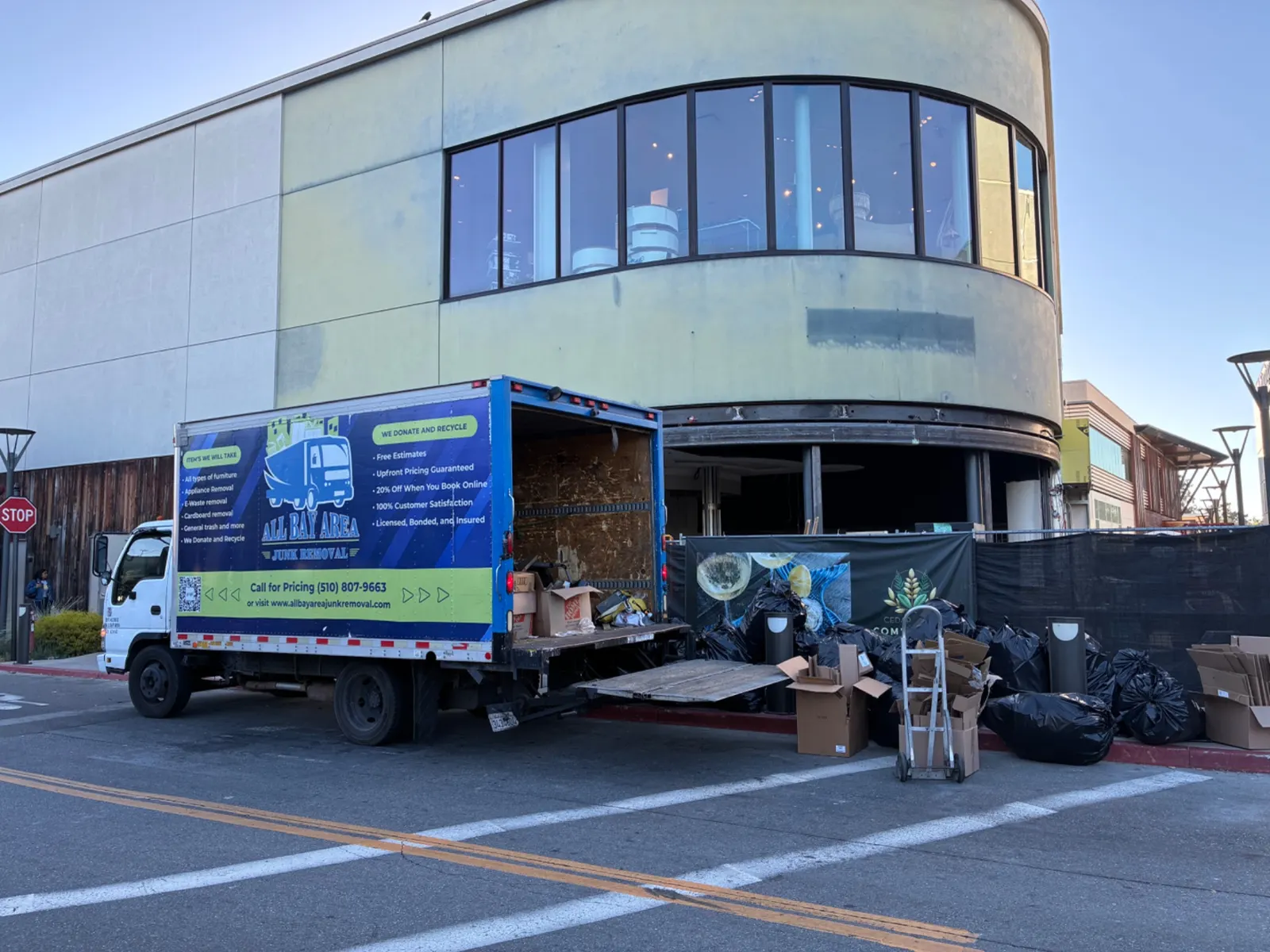 All Bay Area Junk Removal truck loading outside a commercial building