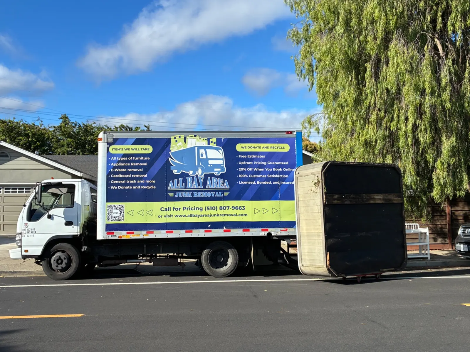 All Bay Area Junk Removal truck on a residential street during a pickup