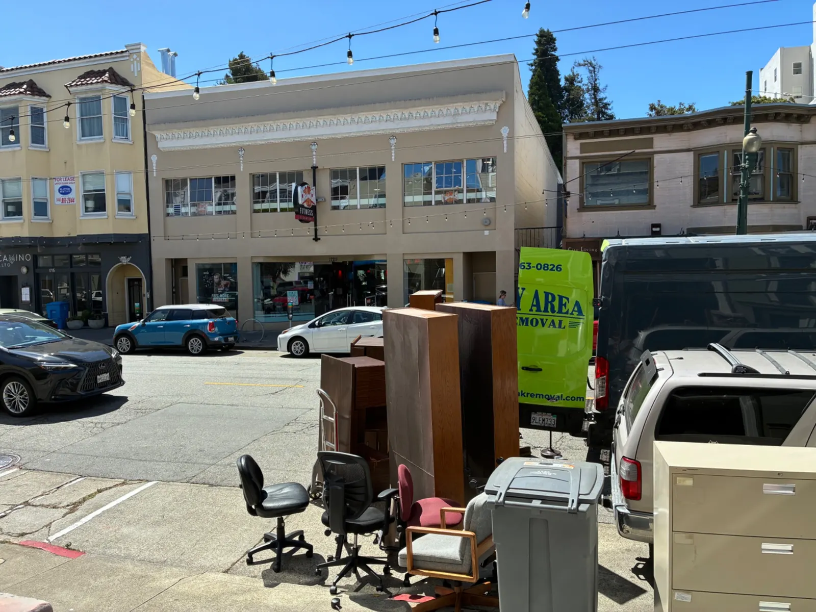Office furniture curbside beside the green company van downtown