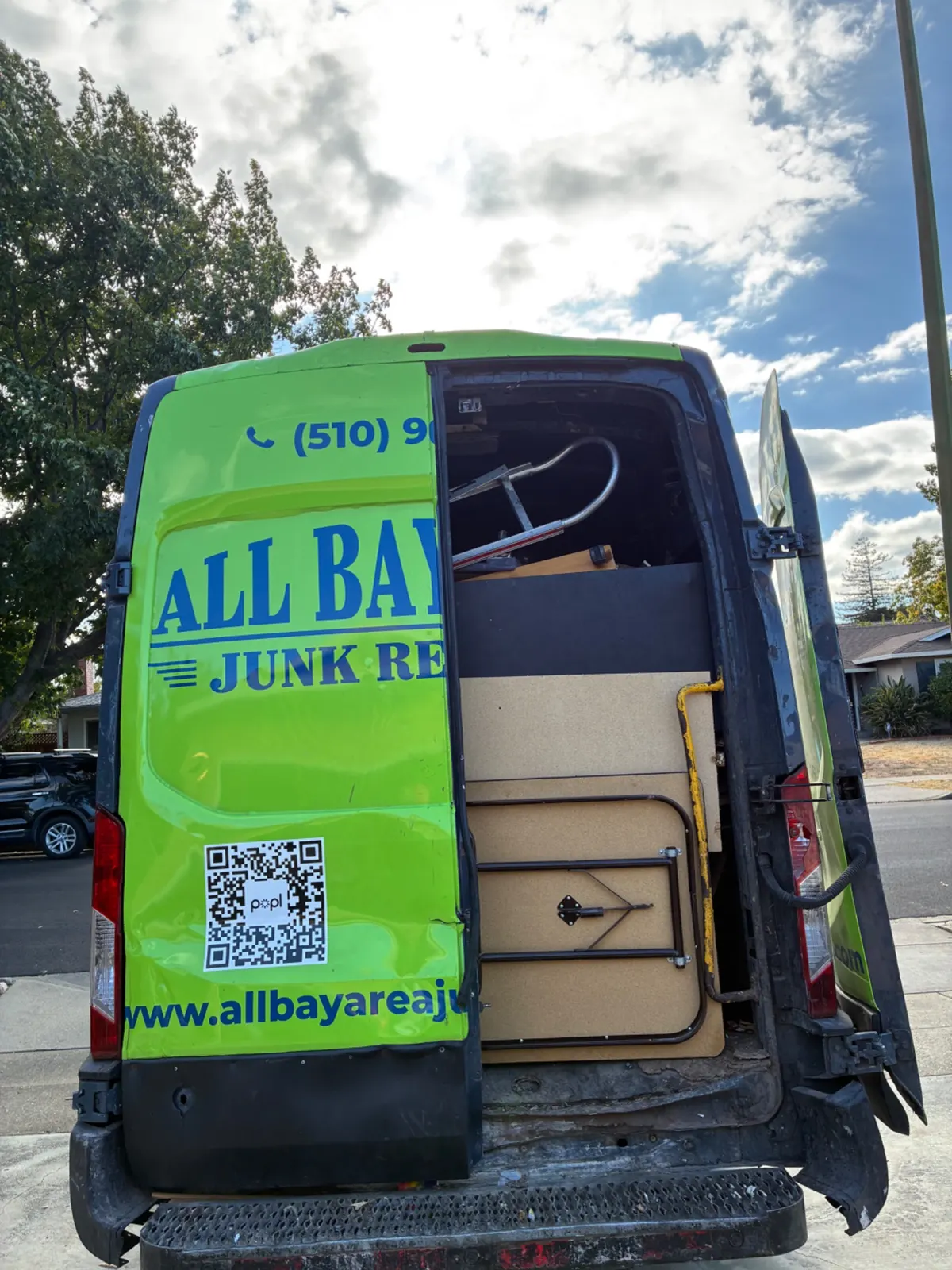 Green All Bay Area Junk Removal van packed with furniture