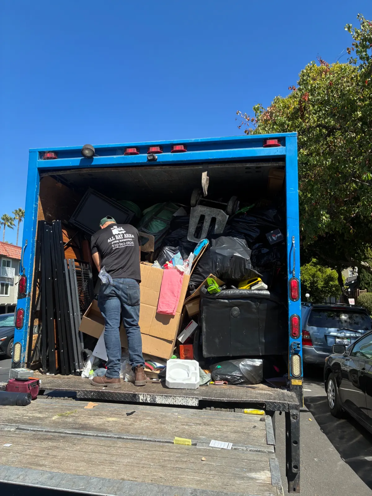 Crew member loading the back of the junk removal truck