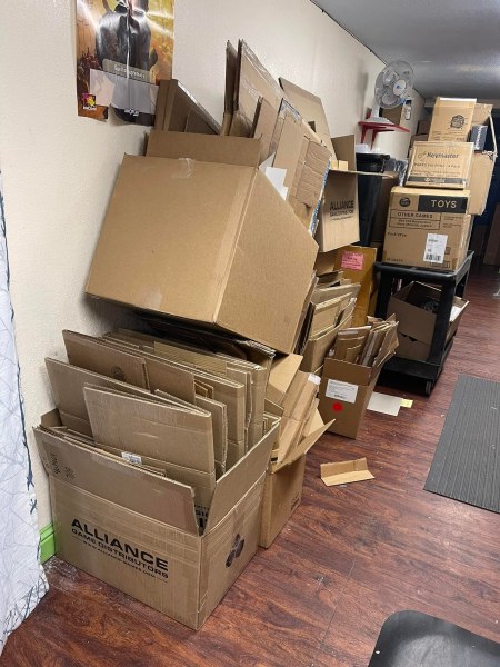 A cluttered storage room in Hayward, California, filled with stacks of cardboard boxes and other miscellaneous items awaiting junk removal.