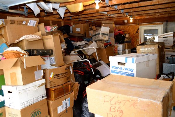 A cluttered storage shed in Hayward, California, filled to the brim with cardboard boxes, furniture, and miscellaneous household items.