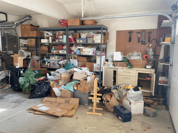 A very cluttered garage in Hayward, California, filled with shelves overflowing with boxes and household items awaiting junk removal.