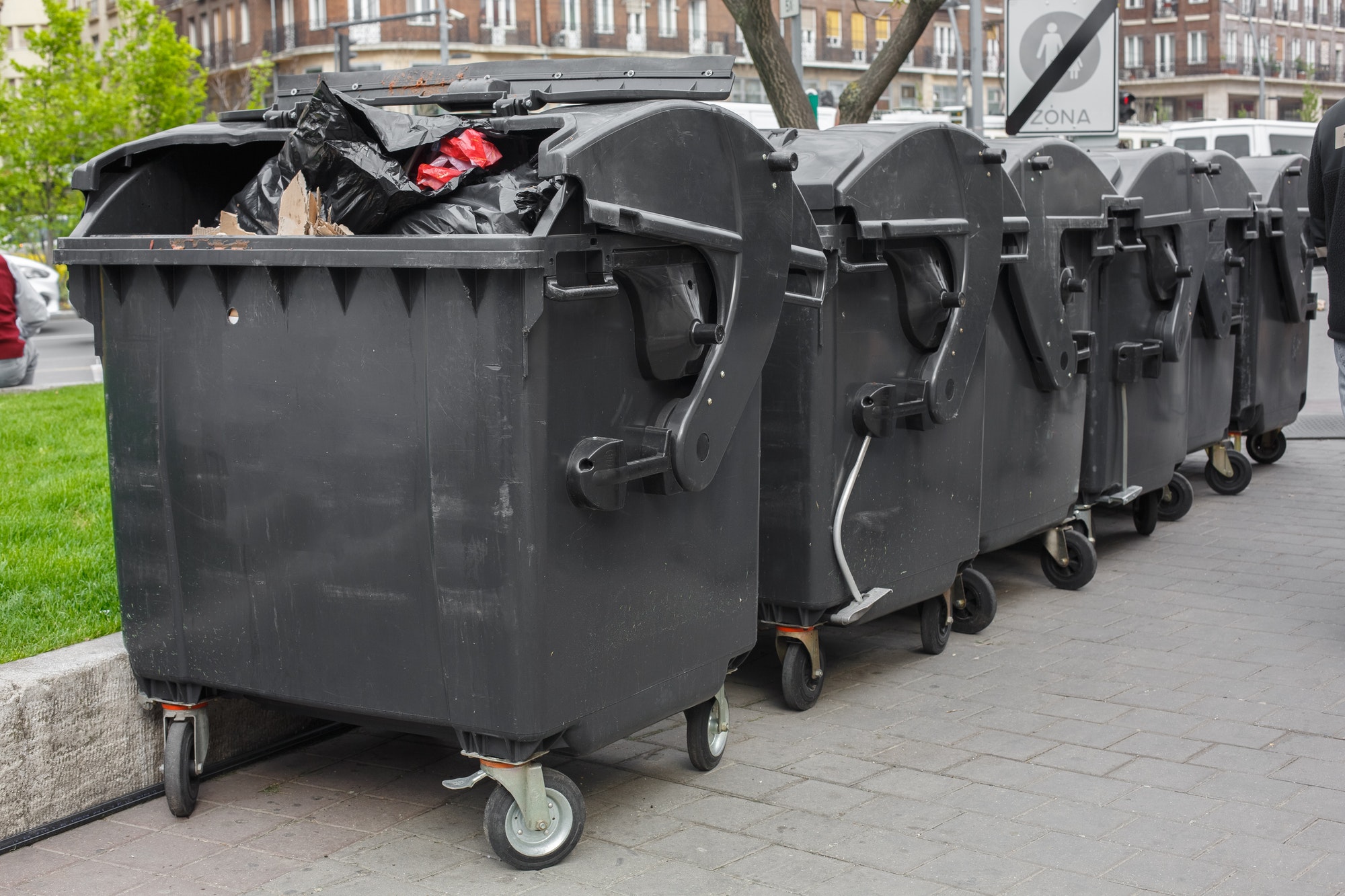Large garbage containers staged on a street for debris removal.